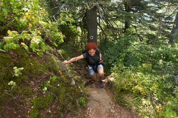 Woman hiker with camera on a trail