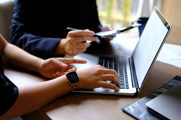 Meeting of business consultants analyzing financial charts and market growth charts to plan investment projects.