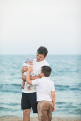 Father and child playing on tropical beach at sunset. Family summer vacation at sea resort. Dad playing with kids on sunny evening at ocean shore. Travel with children. Parent love