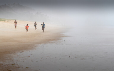 people on the beach running away from storm