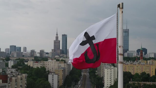 Warsaw, Poland, aerial view of city center and waving polish flag with letter "P" symbolizing Warsaw uprising