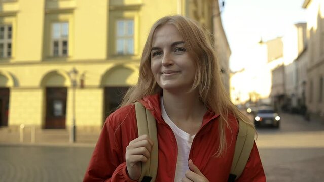 Real view of traveller woman walking on old Market Square in Krakow holding tourist map. Travel and active lifestyle concept. High quality photo. High quality FullHD footage
