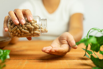 Capsules of plant origin held in hand, nature, laboratory, science of dietary supplements