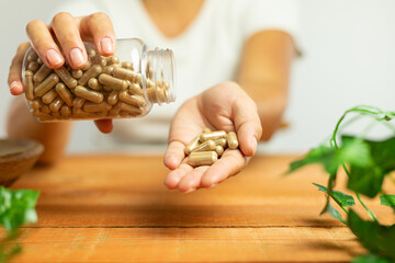 Capsules of plant origin held in hand, nature, laboratory, science of dietary supplements
