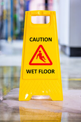Caution Wet floor sign with spilled water on the wet floor in production plant 