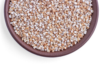 Crushed wheat grain in a brown clay bowl isolated on a white background. Top view with copy space
