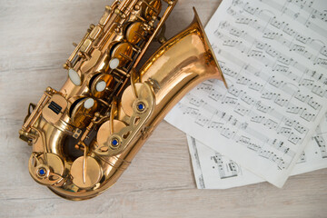 Top view picture of the saxophone laying on the note sheets