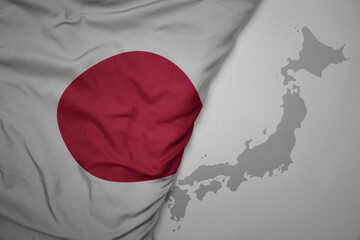 big waving national colorful flag and map of japan on the gray background.