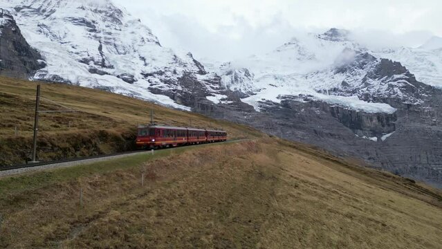 Train headed up to Jungfraujoch through the Eigergletscher station in Grindelwald, Switzerland (Aerial drone video)