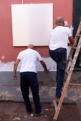 Pintores pintando la fachada de un edificio.