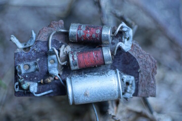 three small metal old radio components on a piece of microcircuit on the street