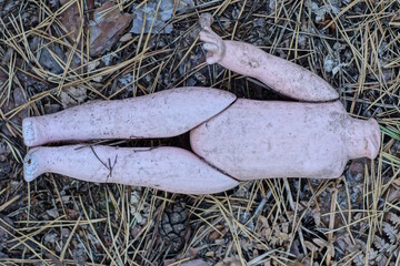 one broken old dirty plastic doll toy without a head lies on the ground on the street