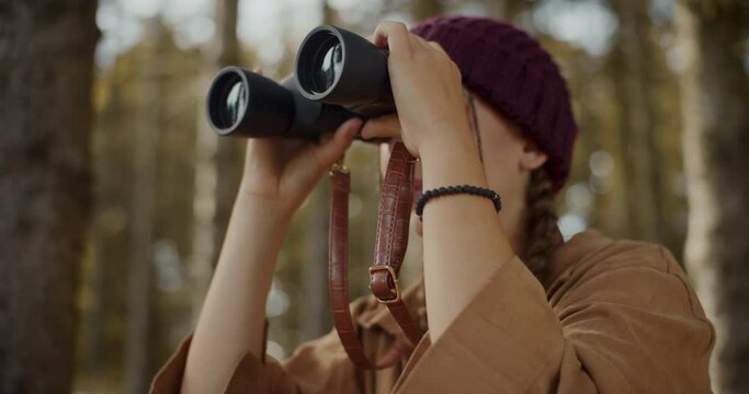 Female explorer searching through binoculars