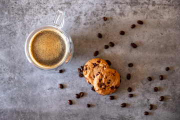 Top view for cup of coffee with cookies and coffee beans on grey background