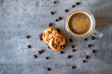 Top view for cup of coffee with cookies and coffee beans on grey background