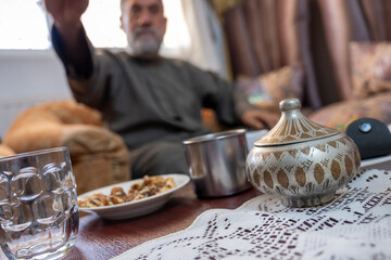 Arabian ornate tin  on living room table with arabic old man in the background