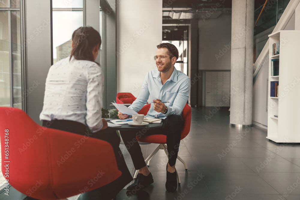 Wall mural two business colleagues working with documents together sitting in office.high quality photo