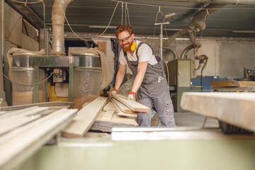 Professional male carpenter working on carpentry manufacturing with wooden board