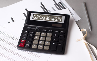 GROSS MARGIN text on calculator with chart on grey background