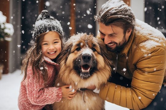 Young caucasian father and daughter outside with their dog in the winter and snow