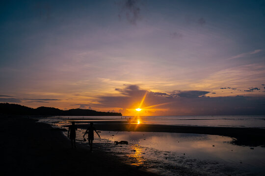 Silhouette of a couple at sunset on the beach. Odiongan, Romblon, Philippines.