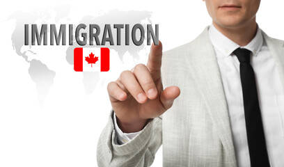Immigration. Businessman touching digital screen with word and flag of Canada on white background, closeup