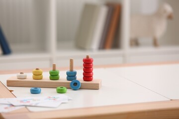 Stacking and counting game on table indoors, space for text. Educational toy for motor skills development