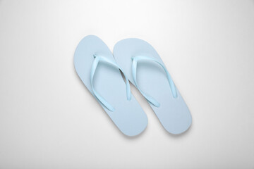 Light blue flip flops on white background, top view