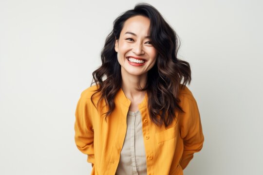 Lifestyle portrait photography of a happy Vietnamese woman in her 30s against a white background