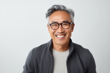 Medium shot portrait photography of a cheerful Vietnamese man in his 50s against a white background