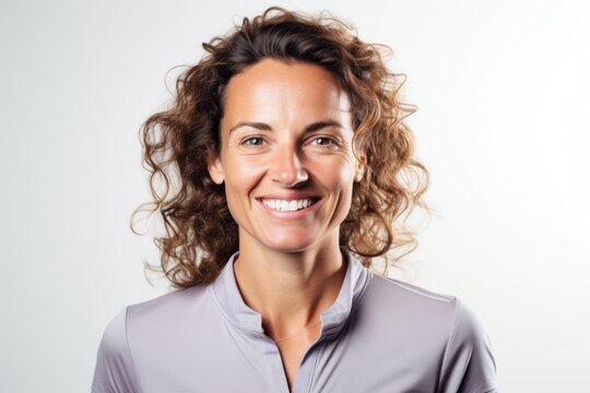 Lifestyle portrait photography of a happy French woman in her 30s wearing a sporty polo shirt against a white background