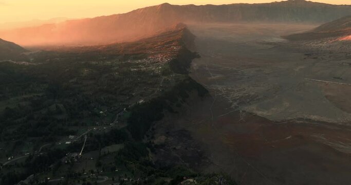Aerial view 4k by drone of beautiful view village in the sunrise morning, near Mount Bromo. Located in Bromo, Tengger, Semeru National Park, East Java, Indonesia. Aerial view bromo volcano concept.