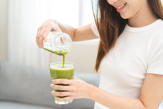 Detox juice concept, Hand of woman, girl holding bottle making green vegetable smoothie pouring in glass for diet at home, female drinking healthy meal food for weight loss. Lifestyle vegan nutrition.