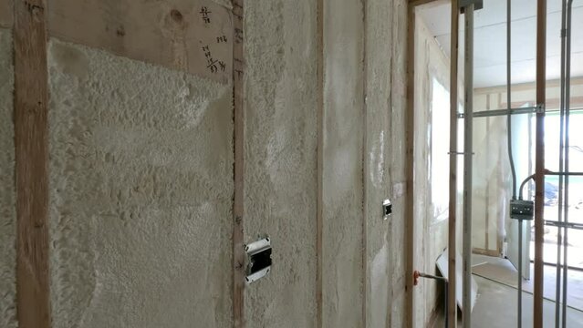 Environmentally friendly housing insulation covering a house. insulation fills up a frame on a wooden wall house under construction.