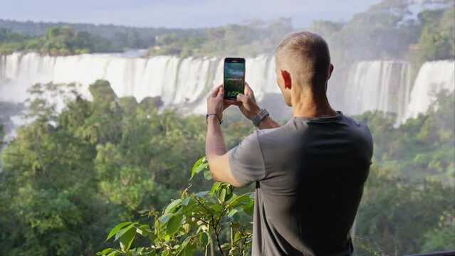 Individual Capturing Images Of The Waterfalls