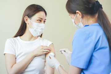 Covid-19,coronavirus hand of young woman nurse,doctor giving syringe vaccine, inject shot to asian...