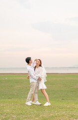 Fototapeta premium Happy young Asian couple in bride and groom clothing
