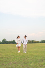 Obraz premium Happy young Asian couple in bride and groom clothing