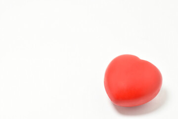 Corazón rojo sobre fondo blanco, concepto de Salud. Espacio para texto al lado izquierdo.