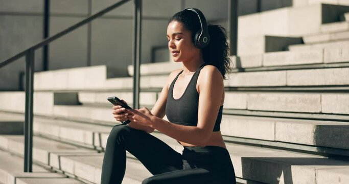 Fitness, woman and headphones with smartphone on stairs for communication, exercise music and relax mindset. Wellness, athlete and phone for listening to radio or audio for training, running and chat