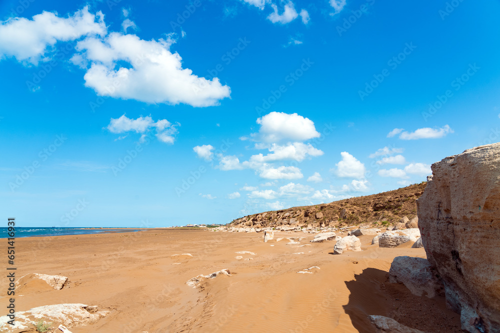 Wall mural Large sandy beach with stone boulders