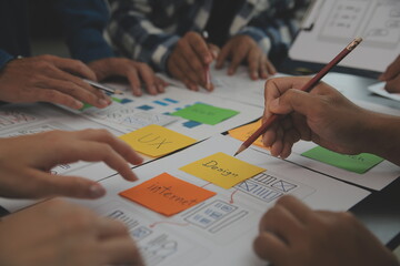 Close up ux developer and ui designer brainstorming about mobile app interface wireframe design on...