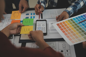 Close up ux developer and ui designer brainstorming about mobile app interface wireframe design on...