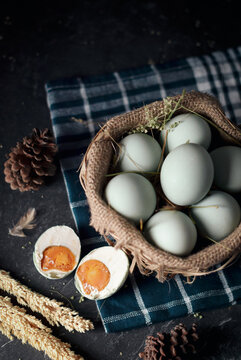 salted eggs, duck eggs in the bamboo basket and sackcloth with dark background. split salted eggs.