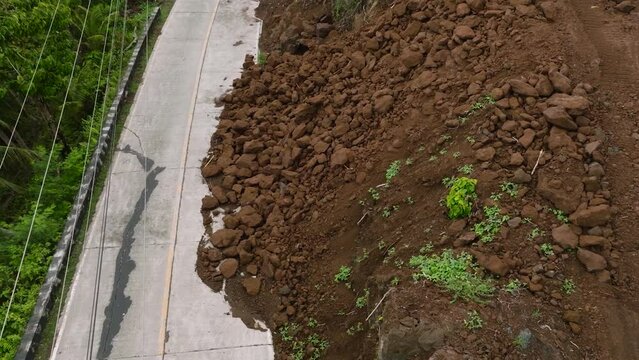 Camiguin Island: Aerial view of mud and rocks blocking the road after rain. Landslides with rocks and soil. Philippines.