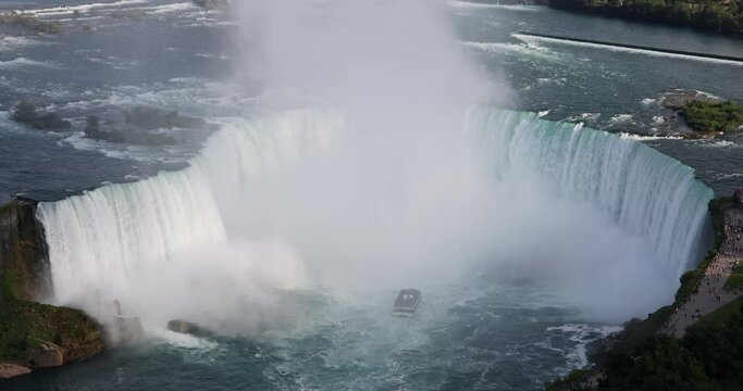 High angle, close-up view of the Horseshoe falls in Niagara Falls, Canada, while tourist boat is nearing the falls