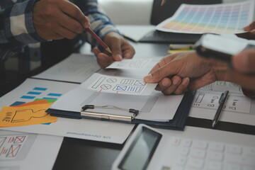 Close up ux developer and ui designer brainstorming about mobile app interface wireframe design on...