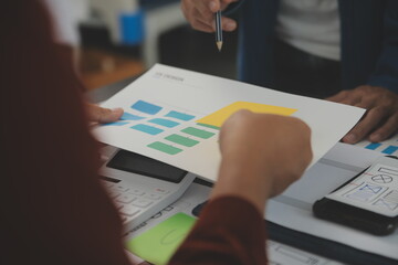 Close up ux developer and ui designer brainstorming about mobile app interface wireframe design on...