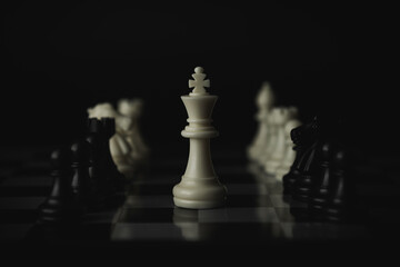 Pieces on chess board on black background for playing game and strategy.