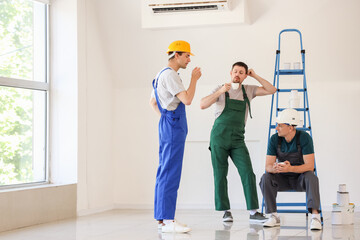 Team of male builders during coffee break in room